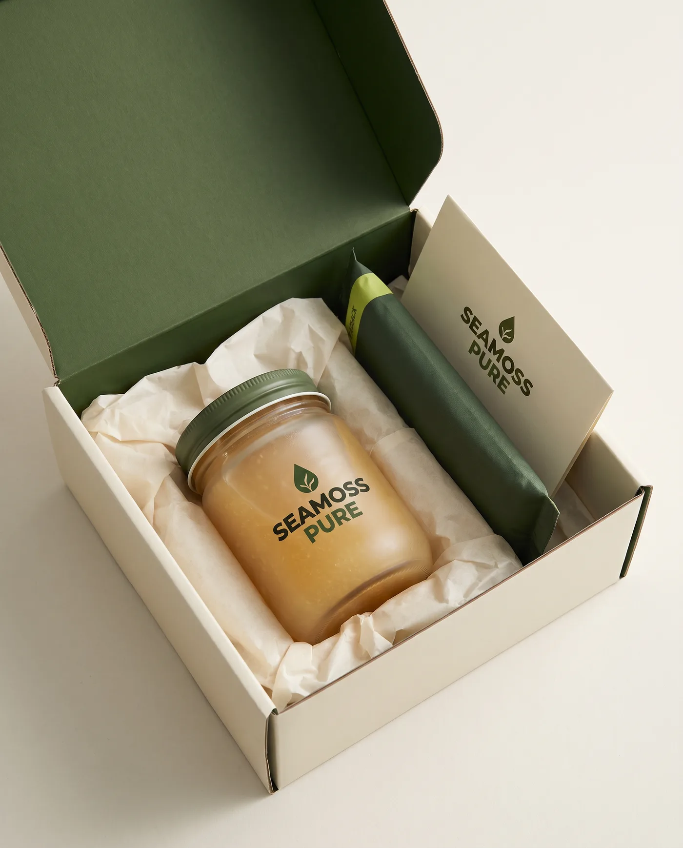An open shipping box with a jar nested in cream tissue, a cold pack and a printed card.
